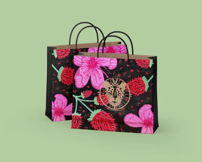 Black shopping bags with red and pink flower designs on green background