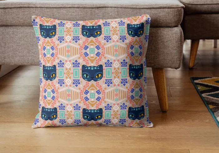 Square pillow with colorful cat faces and geometric designs