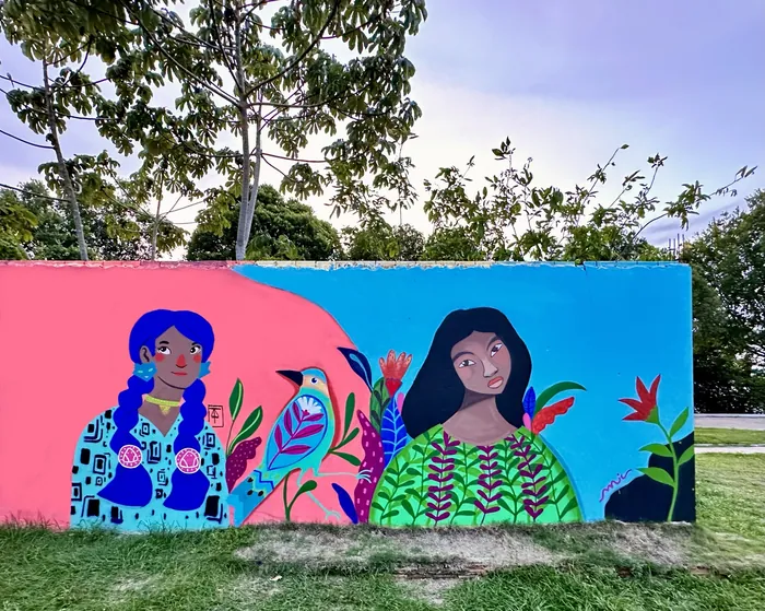 Mural showing two women with plants and birds on colorful background