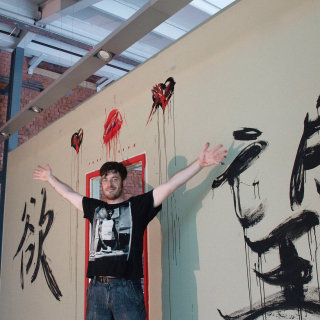 Evento ao vivo desenhando homem com letras na parede
