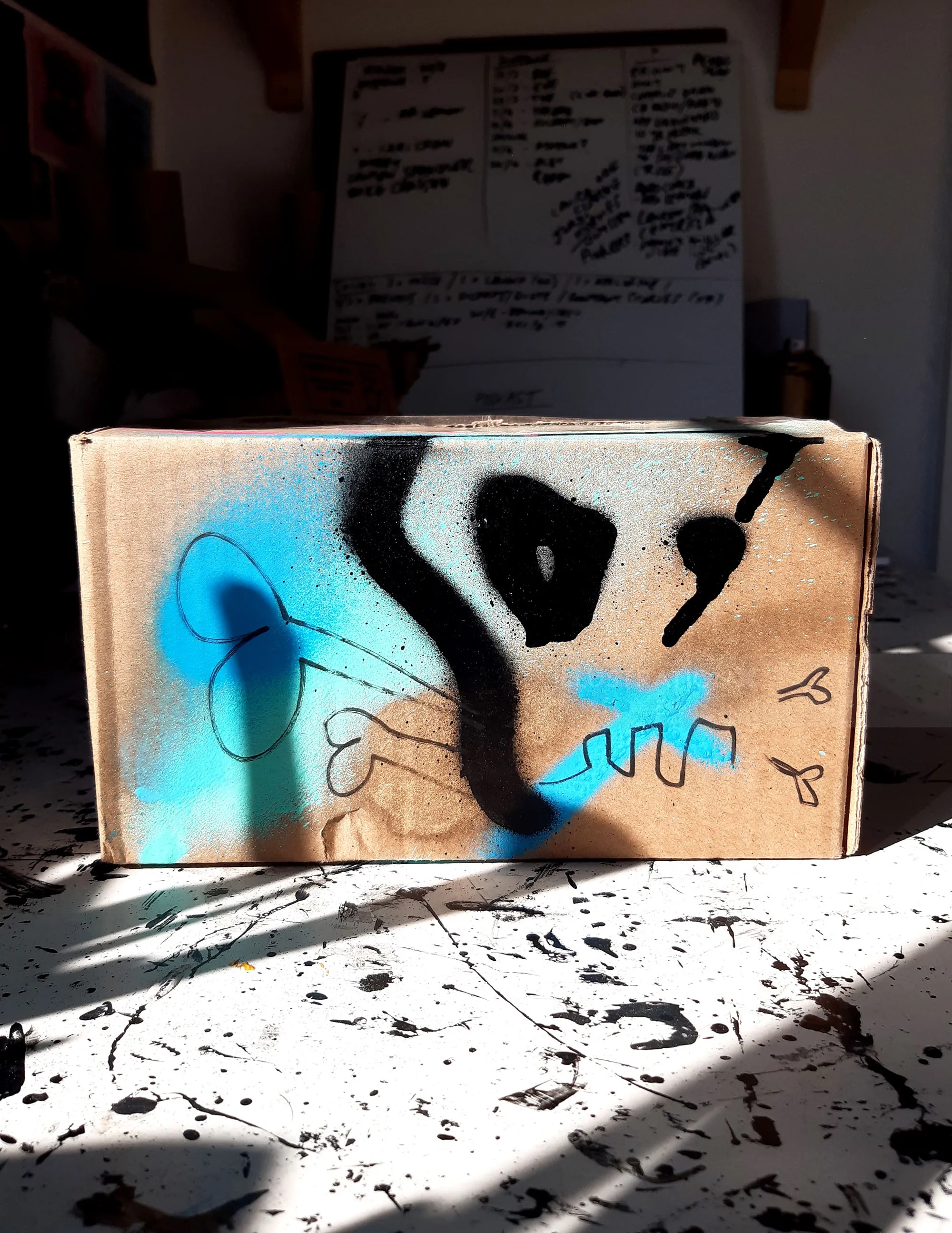 Cardboard box with colorful spray paint skull design
