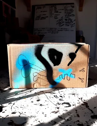 Cardboard box with colorful spray paint skull design
