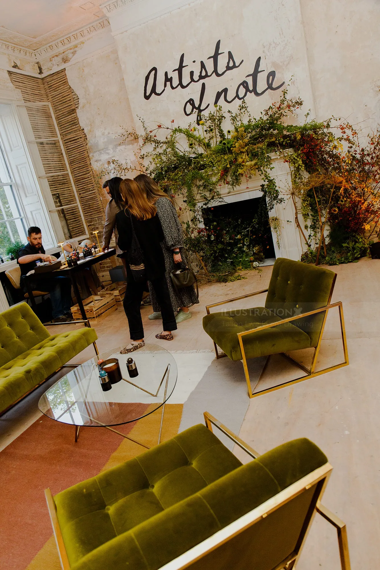 Artists chatting in a cozy studio with green chairs and plants