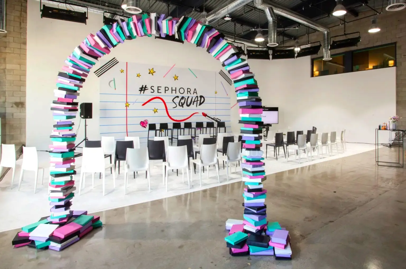 Colorful Sephora Squad event stage with book arch and chairs