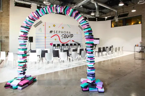 Colorful Sephora Squad event stage with book arch and chairs