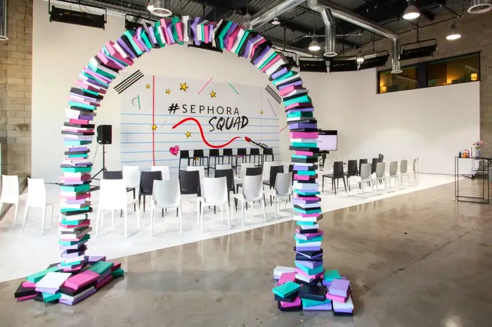Colorful Sephora Squad event stage with book arch and chairs