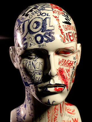 Mannequin head covered with handwritten text in black and red ink