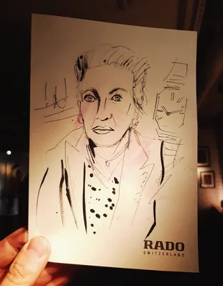 Hand holding a stylish ink portrait sketch of a woman with polka dot blouse