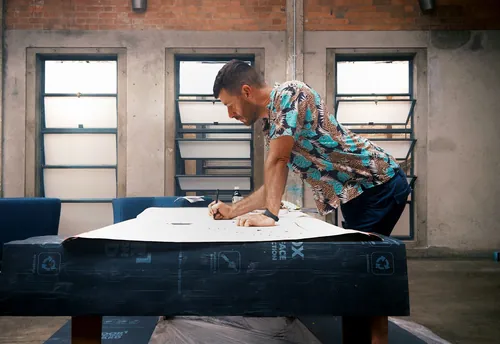Man sketching on large paper in creative studio with brick walls