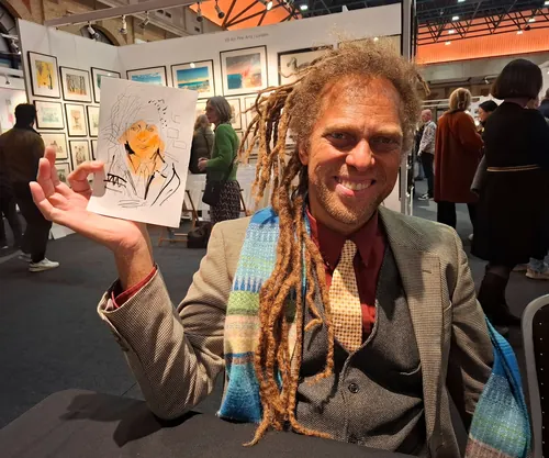 Man with dreadlocks smiling and holding ink and watercolor portrait by Tallon