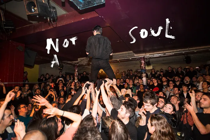 Man standing on crowd's hands at lively concert