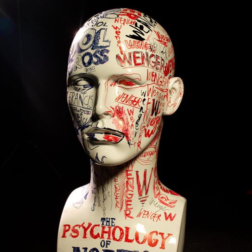 Mannequin head with red and blue graffiti text about North London football