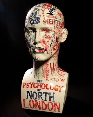 Mannequin head with red and blue graffiti text about North London football