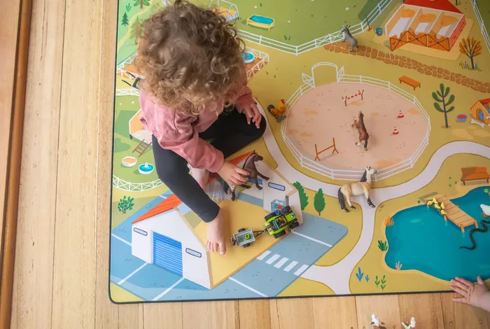 Girl playing with farm play mat