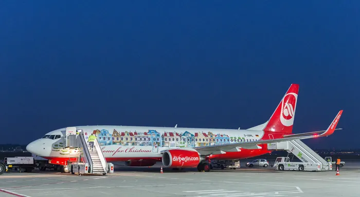 Airplane with vibrant artwork on side parked at airport at night