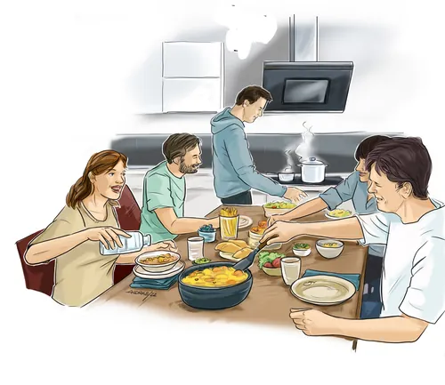 Friends eating and cooking together around a kitchen table