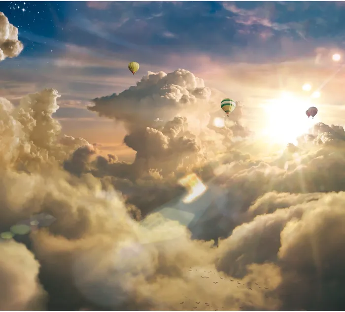 Hot air balloons floating above clouds near sunset by Tom Krieger
