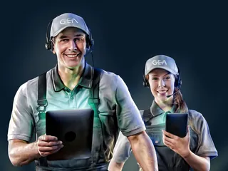 Smiling technicians in GEA uniforms holding tablets, by Tom Krieger
