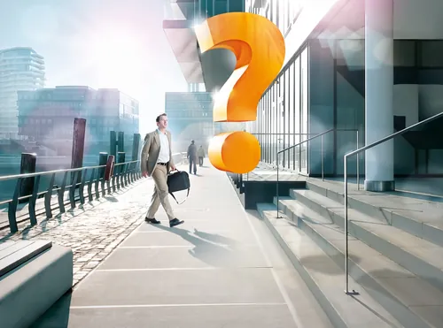 Businessman walking past giant orange question mark sculpture by Tom Krieger