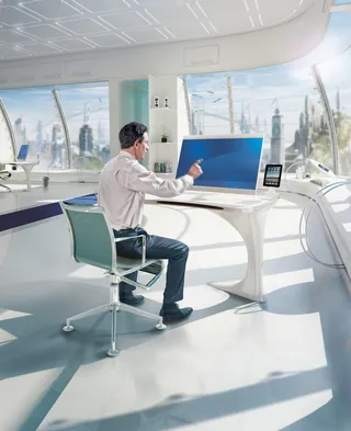 Man using large transparent touchscreen desk in office with city view by Tom Krieger