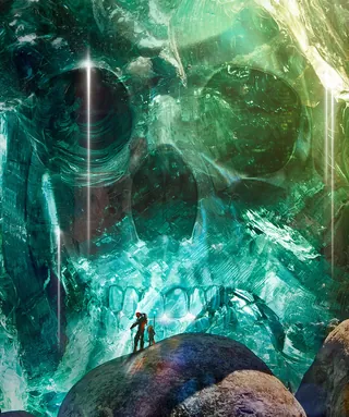 Two people near giant crystal skull glowing inside a cavern by Tom Krieger