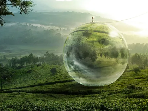 Reflective floating sphere over green landscape by Tom Krieger