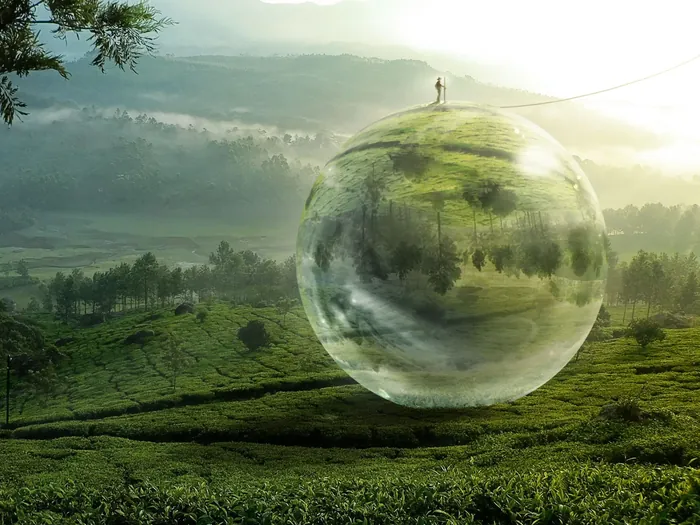 Reflective floating sphere over green landscape by Tom Krieger