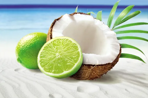 Coconut and lime on white sand beach by Tom Ungemach