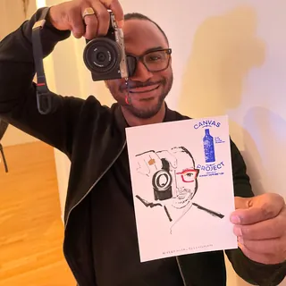 Man holding camera and hand-drawn portrait by Veronica Collignon