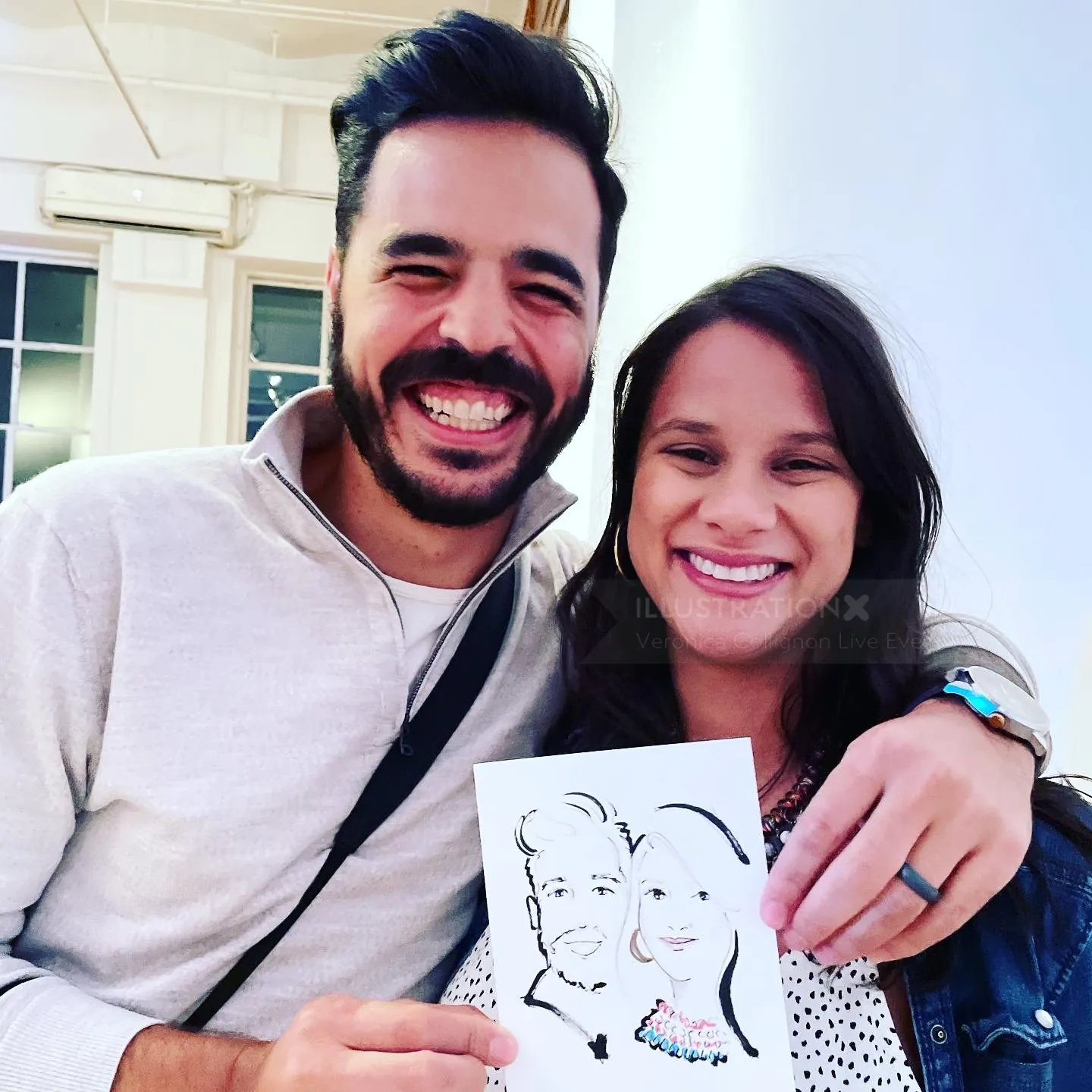 Smiling couple holding caricature drawing by Veronica Collignon
