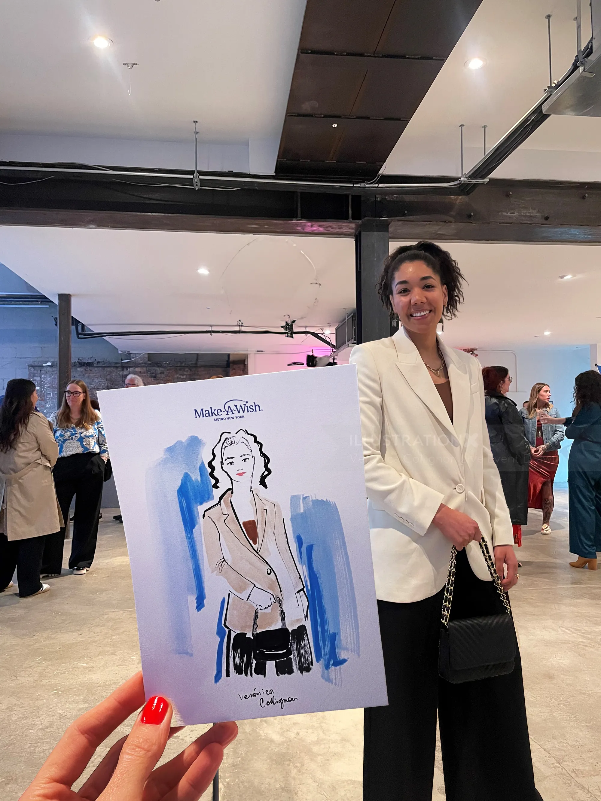 Hand holding fashion sketch of woman in blazer in gallery with attendees