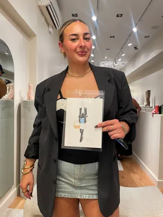 Woman holding fashion drawing inside contemporary art gallery