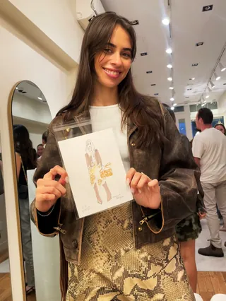 Smiling woman holding an art print in an indoor gallery