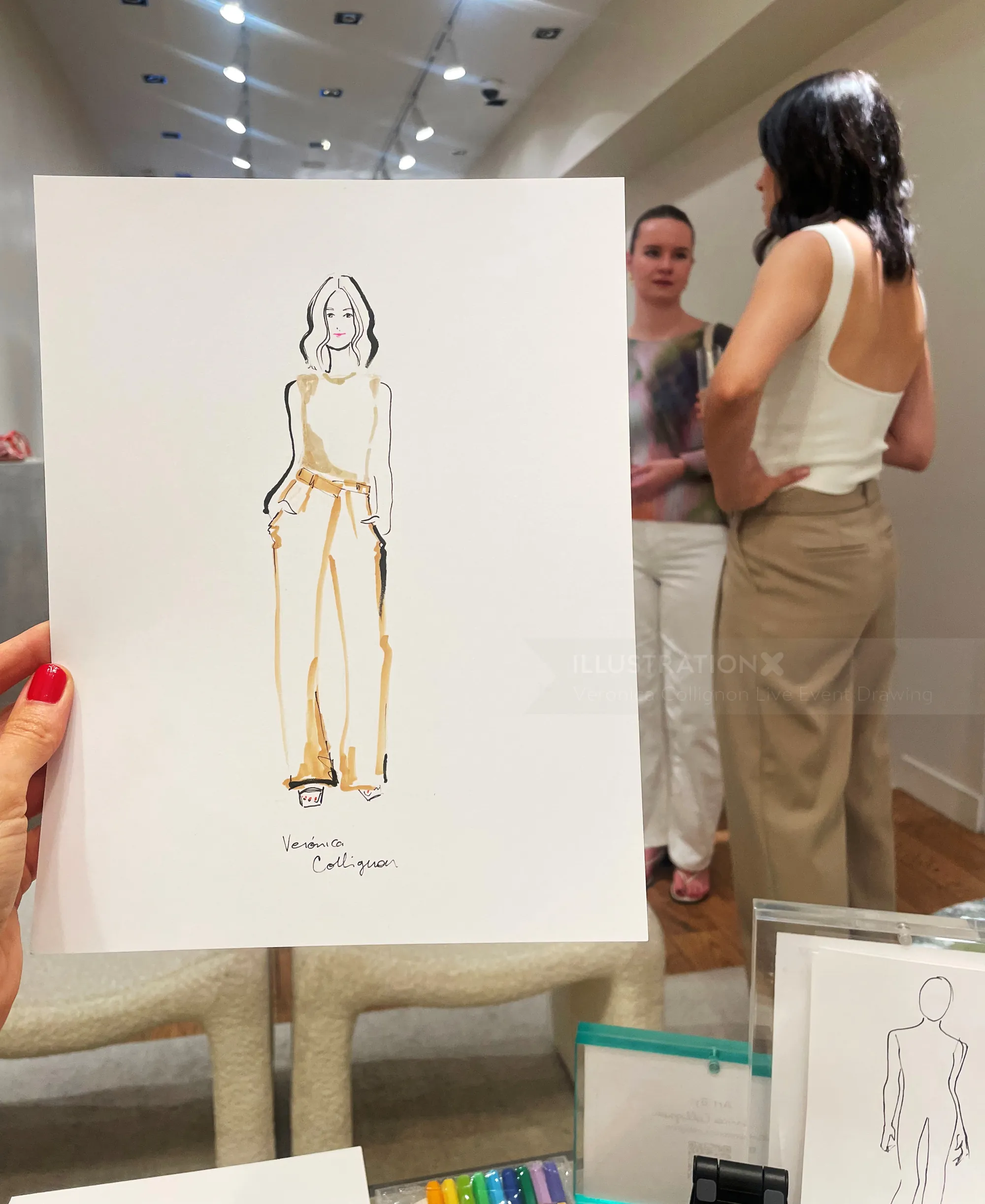 Fashion illustration held up with two women standing and talking behind