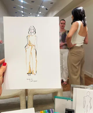 Fashion illustration held up with two women standing and talking behind