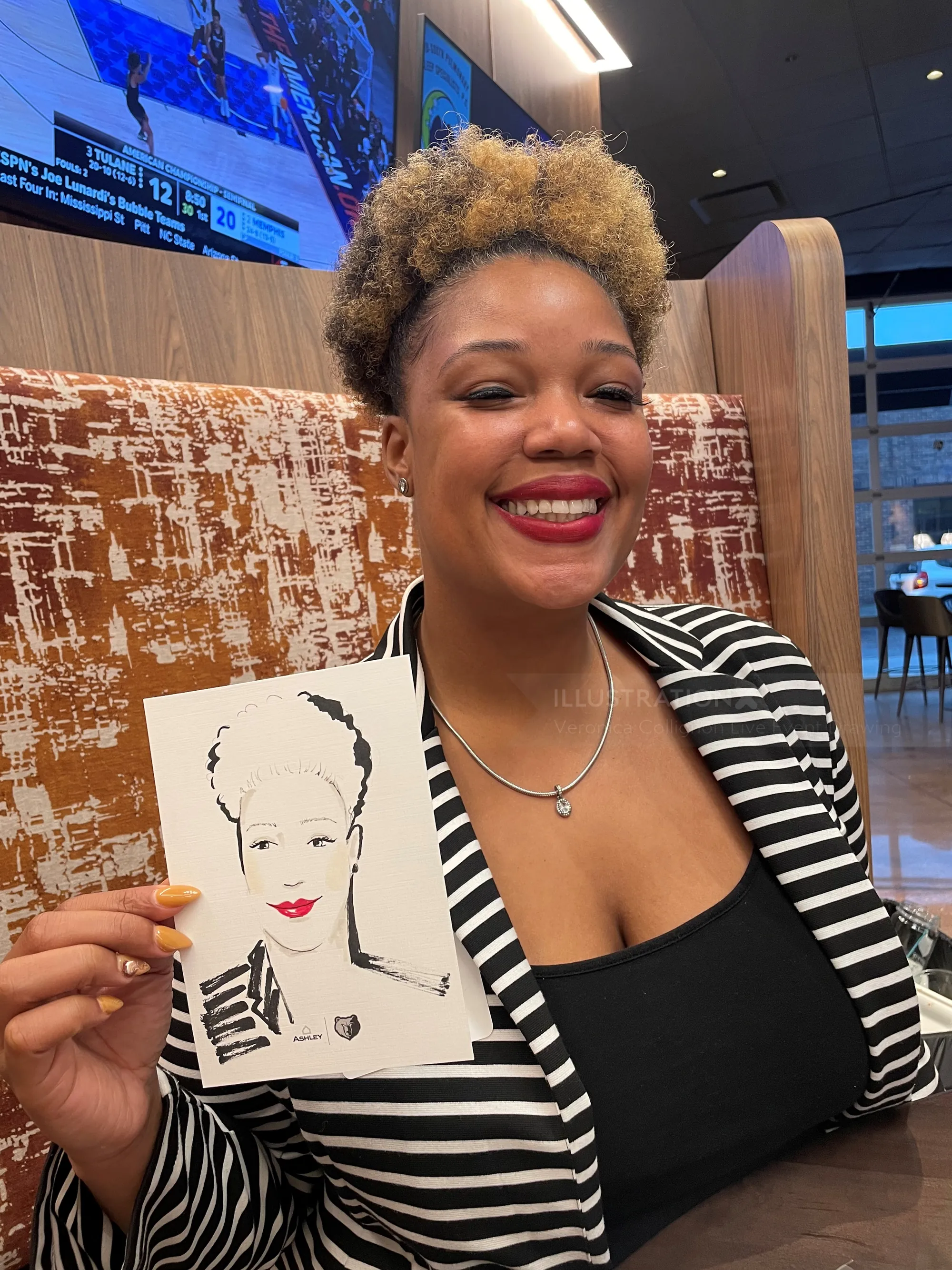 Woman smiling and holding a portrait sketch in a cafe