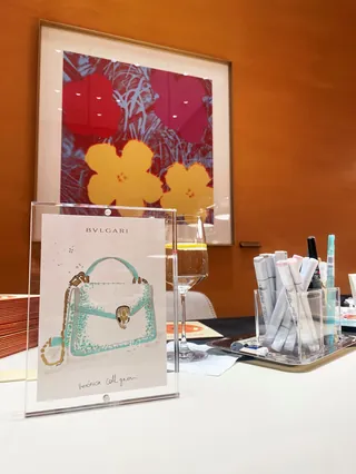 Bvlgari handbag display with makeup brushes and colorful framed artwork