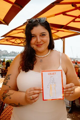 Woman smiling and holding Lillet drink menu at outdoor patio
