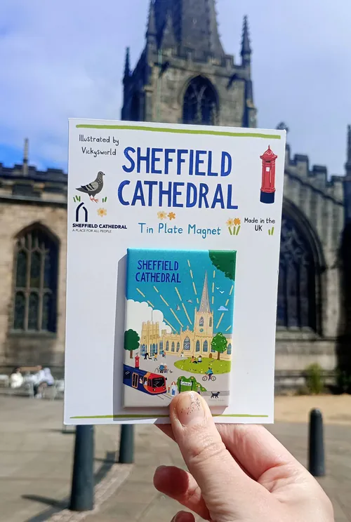 Ímã de lata da Catedral de Sheffield, pertencente ao aluno Vicky Scott, exibido em frente à catedral.