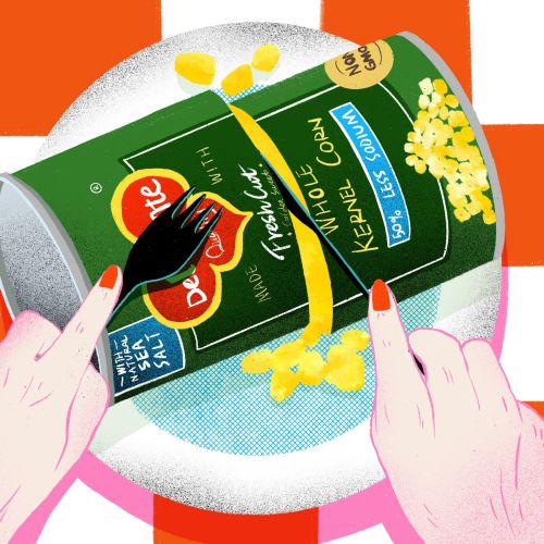 Hands opening a can of sweet corn on a plate with a fork