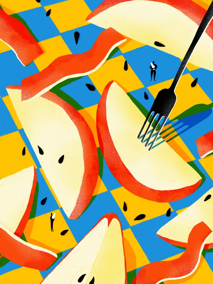 Fork with apple slices on colorful checkered tablecloth