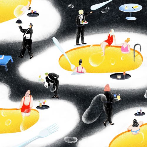 People relaxing in yellow pools with waiters serving drinks