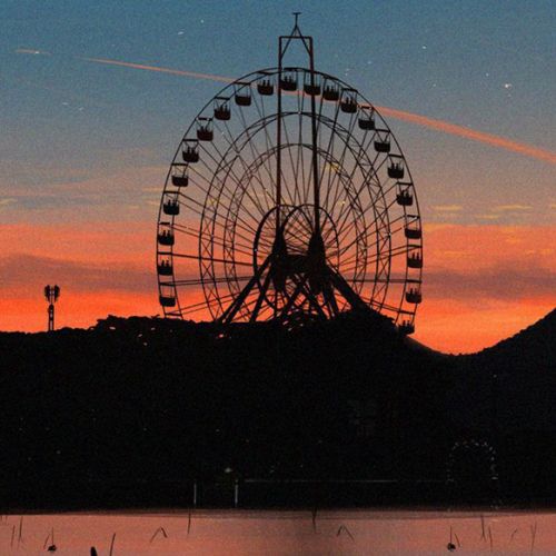 A ferris wheel against a sunset sky