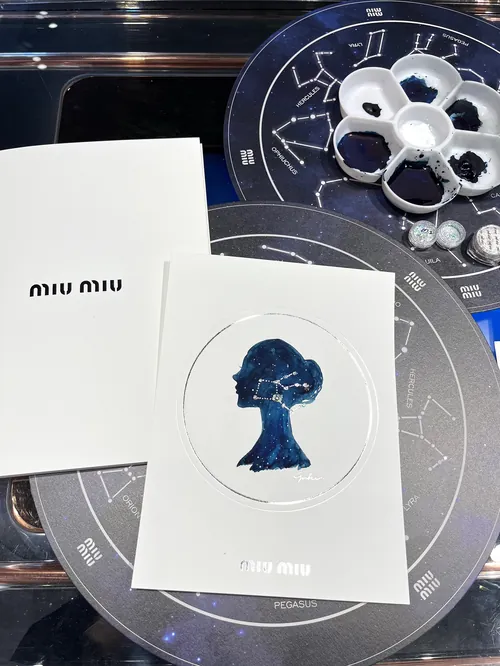 MIU MIU event cards with blue silhouette and constellation backdrop