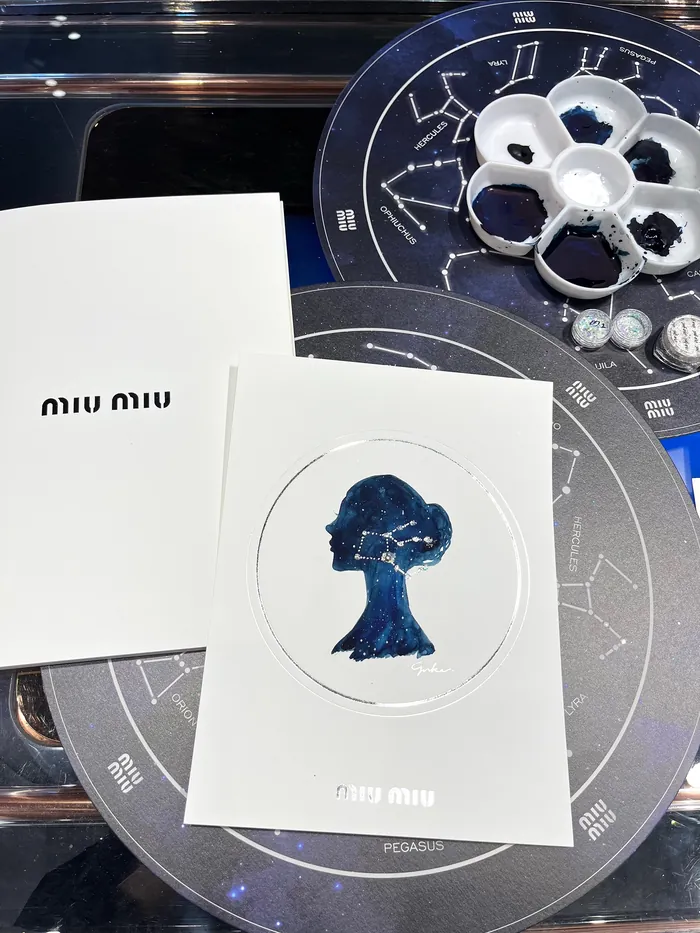 MIU MIU event cards with blue silhouette and constellation backdrop
