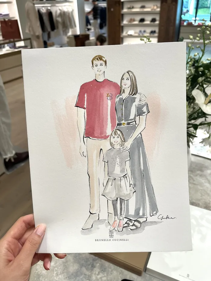 Hand holding fashion illustration of family at Brunello Cucinelli event
