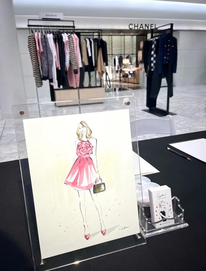 Fashion sketch of woman in pink dress with clothing rack and Chanel store