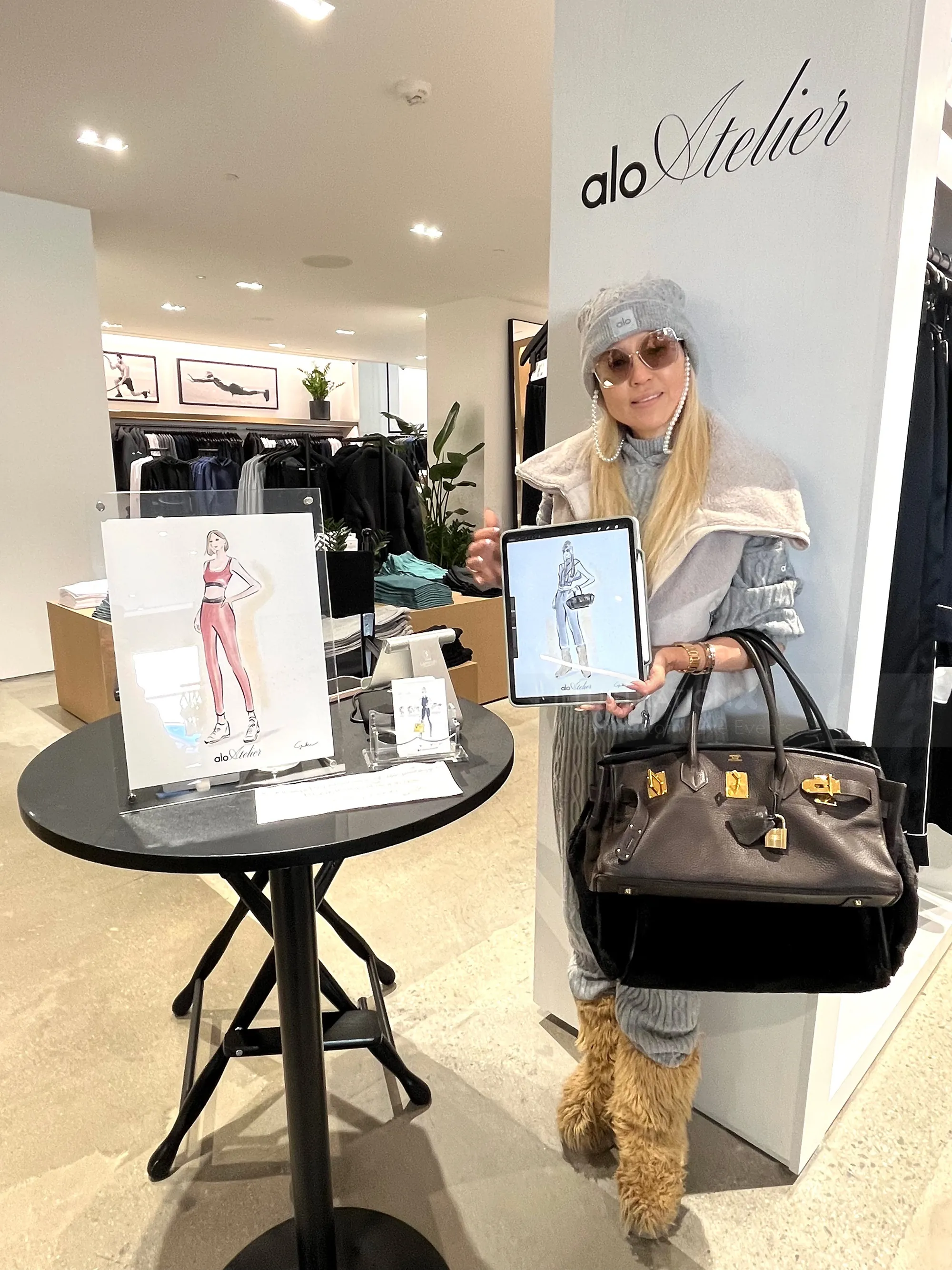 Woman at Alo Atelier live event holding artwork and handbag