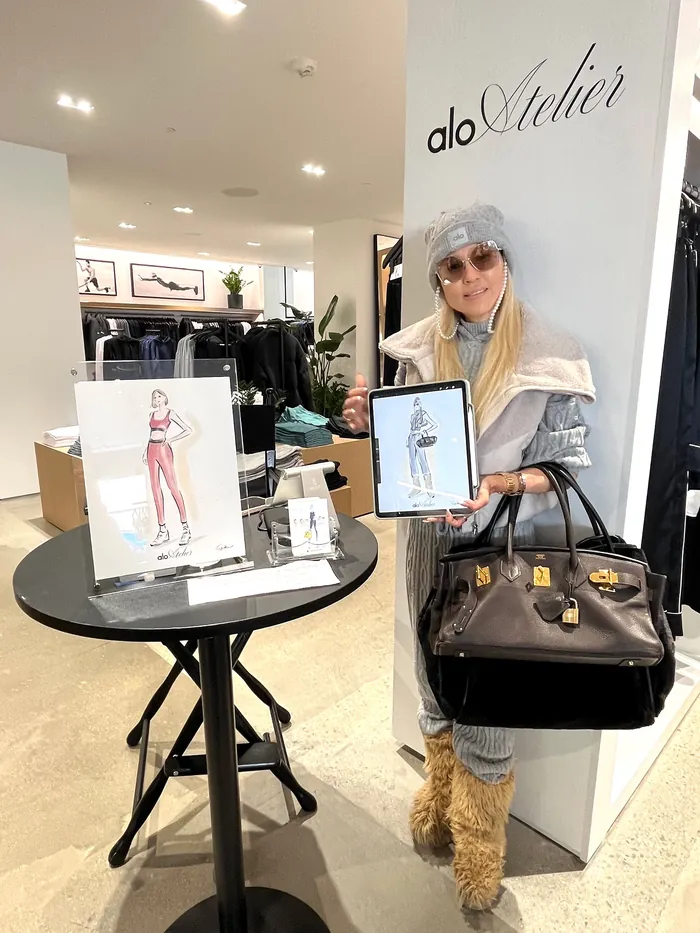 Woman at Alo Atelier live event holding artwork and handbag