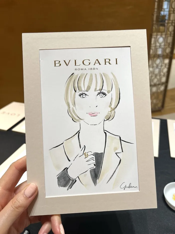 Hand holding a fashion illustration of a woman for Bulgari event